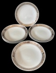 Steatita - Oito pratos fundos em porcelana com aba decorada em tom prateado e detalhes em relevo formando cenas clássicas ao redor da borda. Filete fino próximo à área central. Medindo: 21 x 3,5 cm.