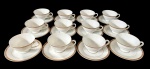 Doze xicaras para chá em porcelana japosena na cor branca, decorada em tom dourado com padronagem geométrica contínua, além de filete fino próximo à área central. Manufatura no verso.