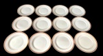 Doze pratos para pão em porcelana japosena na cor branca, decorada em tom dourado com padronagem geométrica contínua, além de filete fino próximo à área central. Manufatura no verso. Medindo: 16,5 cm.