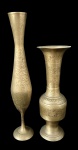 Par de vasos decorativos em metal dourado, com formatos distintos sendo um alongado e esguio com base fina e outro com bojo central mais robusto, ambos ricamente trabalhados com gravações florais e ornamentos em relevo por toda a superfície, bordas levemente abertas e bases estáveis. Medindo: 25 x 8,5 cm e 32,5 x 6 cm.