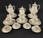 LIMOGES, FRANCE. Antigo conjunto de chá e café em porcelana francesa, esmaltada na cor branca, com delicados filetes em ouro na tampa e bordas. Formato clássico e elegante composto de: bule, chaleira, manteigueira, açucareiro, 5 xícaras de chá com pires, 4 xícaras de café com cinco pires e 6 pratos de sobremesa. Medindo: 23 x 21 cm, 20 x 18 cm, 9 x 14 cm,  15 x 14 cm e 18 cm.