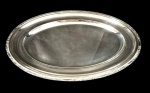 Meridional - Travessa oval em metal prateado com borda decorada em relevo, acabamento polido com marcas de uso e riscos superficiais. Medindo: 43 x 32 cm.