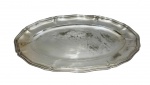 CHRISTOFLE - Bandeja oval em metal prateado com bordas recortadas e aba elevada, apresentando marcas de uso, riscos e desgaste do tempo. Medindo: 50 x 31 cm.