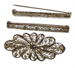 Conjunto de três peças em prata, composto por duas presilhas e um broche com trabalho rendilhado e detalhe central. Peso total: 7,9 gramas. Medidas: 4 cm e 4,5 cm.