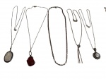 Conjunto com cinco colares em prata, teores 900 e 925, compostos por diferentes estilos de correntes e pingentes. Inclui peças com pedras e detalhes ornamentais, como pingente oval, pedra vermelha e acabamento trabalhado. Possuem tamanhos aproximados de 39 cm, 44 cm e 45 cm, com peso total de 31 gramas.