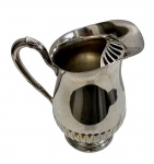 Jarra em metal espessurado à prata; medidas: 19,5 x 22 x 14 cm. Apresenta desgaste.