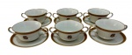 Conjunto de xícaras para consume em porcelana, composto por 6 unidades com seus pires, apresentando fundo na cor branco com elegante faixa superior em tom vinho com detalhes dourados. As peças são decoradas com monograma central.