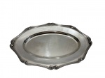 Travessa em metal espessurado a prata da marca Fracalanza, de formato oval com contorno recortado, borda decorada com frisos paralelos e elementos em relevo nos pontos de destaque. Superfície lisa e levemente côncava. Medidas: 44 x 29 cm. Leves desgastes no banho e pequenas marcas.