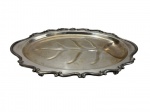 Travessa em metal espessurado a prata, de formato oval com borda recortada e ondulada, apresentando elegante trabalho em relevo ao centro representando motivo vegetal estilizado. Medidas: 7,5 x 31,5 x 47,5 cm. Apresentando sinais do tempo, como desgastes no banho, áreas de oxidação e marcas superficiais.