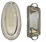 Duas travessas em metal espessurado a prata, sendo uma de formato oval com borda decorada por frisos geométricos e outra de formato retangular com alças laterais, apresentando rica borda rendada em trabalho vazado. Superfícies lisas com cavidade central Medidas: 50 x 22 cm e 60 x 23,5 cm. Apresentando sinais do tempo, como desgastes no banho e pequenas marcas superficiais.