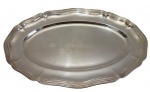 Antiga travessa em metal espessurado a prata, de linhas elegantes com bordas recortadas e frisos em relevo, apresentando superfície lisa com leve pátina do tempo, medidas 40 x 26,5 cm.