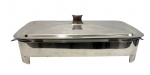 Suporte retangular em prata 90, com tampa e recipiente interno em vidro tipo pirex, apoiado sobre pés e com alças laterais; medidas: 45 x 24 x 12 cm.
