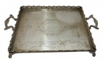 Grande bandeja em metal espessurado a prata, com borda vazada ricamente trabalhada e alças laterais ornamentadas. Fundo decorado com delicados motivos florais gravados. Medidas: 51 x 30,5 x 8 cm.