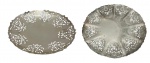 Conjunto com duas bandejas em metal, de formato circular, com bordas vazadas e ricamente trabalhadas em motivos ornamentais. Medidas: 4 x 25 cm e 3 x 30,5 cm.
