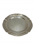 Travessa redonda em metal espessurado a prata, de formato oval com bordas recortadas e aba em relevo. Medidas: 29 cm