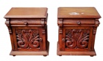 Par de mesas de cabeceira em madeira maciça, com gaveta superior e compartimento inferior com porta decorada por entalhe floral. Peças de estilo clássico, apresentando sinais de uso, com pequenos arranhões em um deles. Medidas: 66 x 41 x 58 cm cada