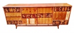 Buffet em madeira, de meados do século XX, com decoração em marchetaria representando figuras estilizadas de inspiração egípcia. Composto por gavetas, compartimentos com portas e área interna com prateleiras e vidro. Apresenta sinais de uso e necessita restauro nas lâminas. Medidas: 87 x 220 x 48 cm