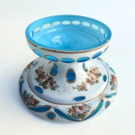 Base em cristal overlay na cor branco leitoso e azul, decoração com pintura floral e lapidações. Ínfimo bicado. Med 21 cm diâmetro 13 cm altura.