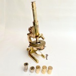 Microscópio alemão antigo, Karl Zeiss Jena (1900-1945). Todo em bronze, acondicionado em caixa original, com chave marcada Z, e fechadura funcionando, acessórios também em bronze. Cerca de 40cm de altura.