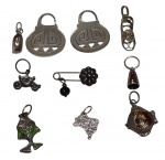 Lote contendo pequenos pingentes e peças em prata, incluindo exemplares decorativos e esmaltados, em variados formatos. Peso total: 21,8 g.