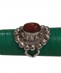 Anel em prata com pedra vermelha em cabochão, adornado por trabalho decorativo em relevo, de estilo étnico. Aro: 26. Peso: 10,6 g.