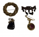 Lote composto por três broches e um pingente em metal, com diferentes estilos e acabamentos, incluindo peças com pedrarias e elemento floral. Tamanhos variados.