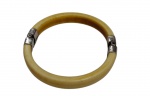 Bracelete rígido em marfim, com guarnições em prata. Peça de estética clássica.