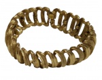 Bracelete em metal dourado, com design vazado e estrutura articulada, de estética marcante e elegante.