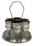 Elegante conjunto composto por suporte circular com alça superior e seis copinhos removíveis, em metal espessurado à prata, delicada decoração em relevo com motivos clássicos e borda perolada no suporte; Medidas do suporte: 12,5 x 14 cm. Medidas dos copinhos: 3,5 x 3,7 cm.