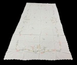 Toalha de mesa na cor branca, decorada com delicados bordados florais em tons suaves e coloridos, distribuídos em guirlandas ao longo das bordas e em pontos centrais. Medidas: 2,85 x 1,50 m.