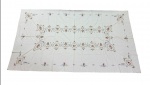 Toalha de mesa em linho, ricamente decorada com bordados policromados formando composição central e bordas com medalhões, guirlandas e elementos ornamentais. Medidas: 3,60 x 1,60 m.