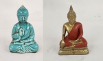 Duas esculturas orientais, representando budas, sendo uma em porcelana na cor azul turquesa e outra em metal dourado com pintura em vermelho. Medindo: 11 x 7 cm e 13 x 8 cm.