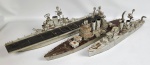 Três maquetes de navios de guerra em madeira.19 x 17 x 67 cm, 22 x 9 x 67 cm e 20 x 7 x 57 cm. No estado, vestígios de cupim.