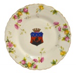 SAXE - Prato em porcelana alemã, com decoração floral no fundo, nos tons rosa, amarelo e verde, apresenta no centro brasão de armas em formato de escudo, com desenho de navio a vela, com bordas onduladas, com acabamento em fio dourado, Sec. XIX; Medindo 24,5 cm