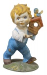 BISCUIT - Antiga escultura confeccionado em pasta de porcelana, esmaltado e policromado, na forma de menino com casa e passarinho na mão; Medindo 13 X 9,5 cm