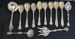 Talheres diversos confeccionados em metal espessurado a prata, incluindo concha, colheres e garfos para serviço, além de peças com decoração vazada e relevos ornamentais, apresentando cabos trabalhados e variados estilos, característicos de diferentes épocas. Medidas variando entre 21 e 24 cm.