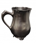 FRACALANZA. Antiga jarra de água confeccionada em metal espessurado à prata, de formato, apresentando alça lateral robusta e detalhes decorativos discretos em relevo. Medida: 19 cm de altura.