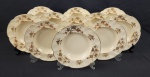 Johnson Bros., Inglaterra - Onze pratos fundos em faiança inglesa, na cor creme, decorados com motivos florais policromados e borda ondulada. Manufatura no verso. Medindo: 3,5 x 22,5 cm. Craquelê e leves manchinhas.