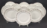 Porcelana Tcheca - Onze pratos rasos em porcelana, na cor branca, decorados com friso floral policromado na borda, detalhe em relevo e filetes em ouro. Manufatura no verso. Medindo: 25 cm. 5 com bicados.