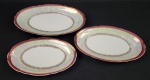 Real, Brasil – Três travessas rasas em porcelana esmaltada e vitrificada, na cor branca, com borda furta-cor, faixa vermelha e detalhes dourados. Manufatura no verso. Medindo: 32,5 x 20 cm, 29 x 18 cm e 36,5 x 23 cm.