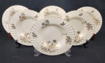 Mintons, Inglaterra, século XX – Seis belíssimos pratos fundo em porcelana inglesa na cor marfim, decorados com flores e frisos em ouro. Bordas onduladas. Manufatura no verso. Medindo: 3,5 x 23 cm. Em ótimo estado.