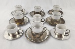 Conjunto de 6 xícaras em porcelana branca com suporte e pires e metal espessurado à prata. Acompanham mais 3 xícaras de outro modelo. Total de 9 peças. 