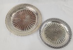 Duas bandejas redondas em metal espessurado à prata, borda vazada e rendilhada. Medindo; 28 cm e 34 cm. Necessita banho de prata.