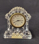 Relógio de mesa em cristal Waterford Crystal. Corpo em cristal lapidado com decoração geométrica em relevo, formato clássico de arco. Mostrador circular com numeração romana, mecanismo quartz (Japan). Medidas: 7,5 x 6,5 x 3 cm.