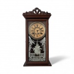 PERIODO 1900 - Relógio de parede Ansonia Clock Co., EUA, início do século XX. Caixa em madeira entalhada, mostrador original com numeração romana e escala interna de 24 horas. Porta frontal com vidro decorado em gravação vegetal e pêndulo metálico trabalhado. Peça de época, preservada e de elegante presença decorativa. Funcionamento a corda. Bate a cada meia hora. Acompanha pêndulo e chave. Mede 52 x 25 cm.