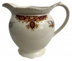 INGLATERRA - Leiteira em faiança inglesa, marca Woods  Ivory Ware, Inglaterra.Peça de corpo bojudo, bico vertedor e alça lateral, decoração floral policromada com guirlanda em tom vinho e detalhes dourados. Base marcada e época início séc. XX.Estado de conservação compatível com a idade, com leves sinais de uso. Mede 17 cm.