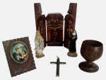 Lote com conjunto religioso, composto por tríptico em madeira entalhada com Cristo Crucificado e figuras sacras, duas imagens devocionais (Nossa Senhora e santa), pequena moldura com imagem sacra, crucifixo metálico e taça/cálice em madeira entalhada. Peças decorativas e de devoção, com pátina do tempo. total de 7 peças, medida do maior 14cm.