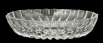 Petisqueira em cristal incolor, formato oval com borda recortada, ricamente lapidada com padrão geométrico facetado e estrela central. Mede 13cm x 20cm.