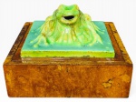 DIVERSOS, uma (1) caixa porta joias, quadrangular, confeccionada em madeira, com aplicação de escultura em faiança vitrificada na tonalidade verde representando sapo, medindo 12x17x17cm.