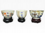 PORCELANA MEISSEN (A fábrica real foi estabelecida em 1710 sob o patrocínio de Augusto, o Forte, Rei da Polônia e Eleitor da Saxônia, fabricadas na cidade de Meien, na Alemanha, centro da primeira porcelana de pasta dura europeia), três (3) bowls, confeccionados em porcelana alemã na tonalidade branca, decorados por elementos florais e vegetalistas em policromia com realces em ouro, todos apoiados sobre peanha circular em madeira em vazados, medindo 5x8cm (bicado), 4,5x7cm e 4,5x6,5cm.